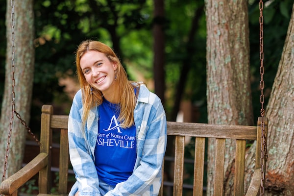 a female UNCA student sitting on a bench outdoors
