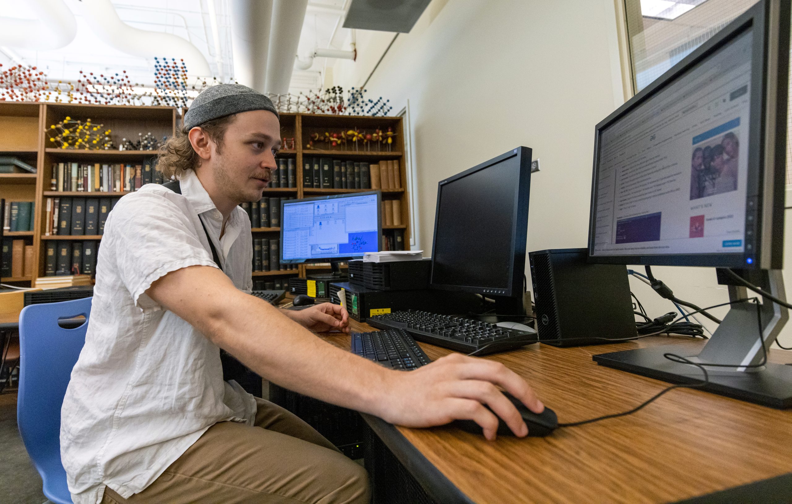 Someone sitting at a computer working on an undergraduate research project