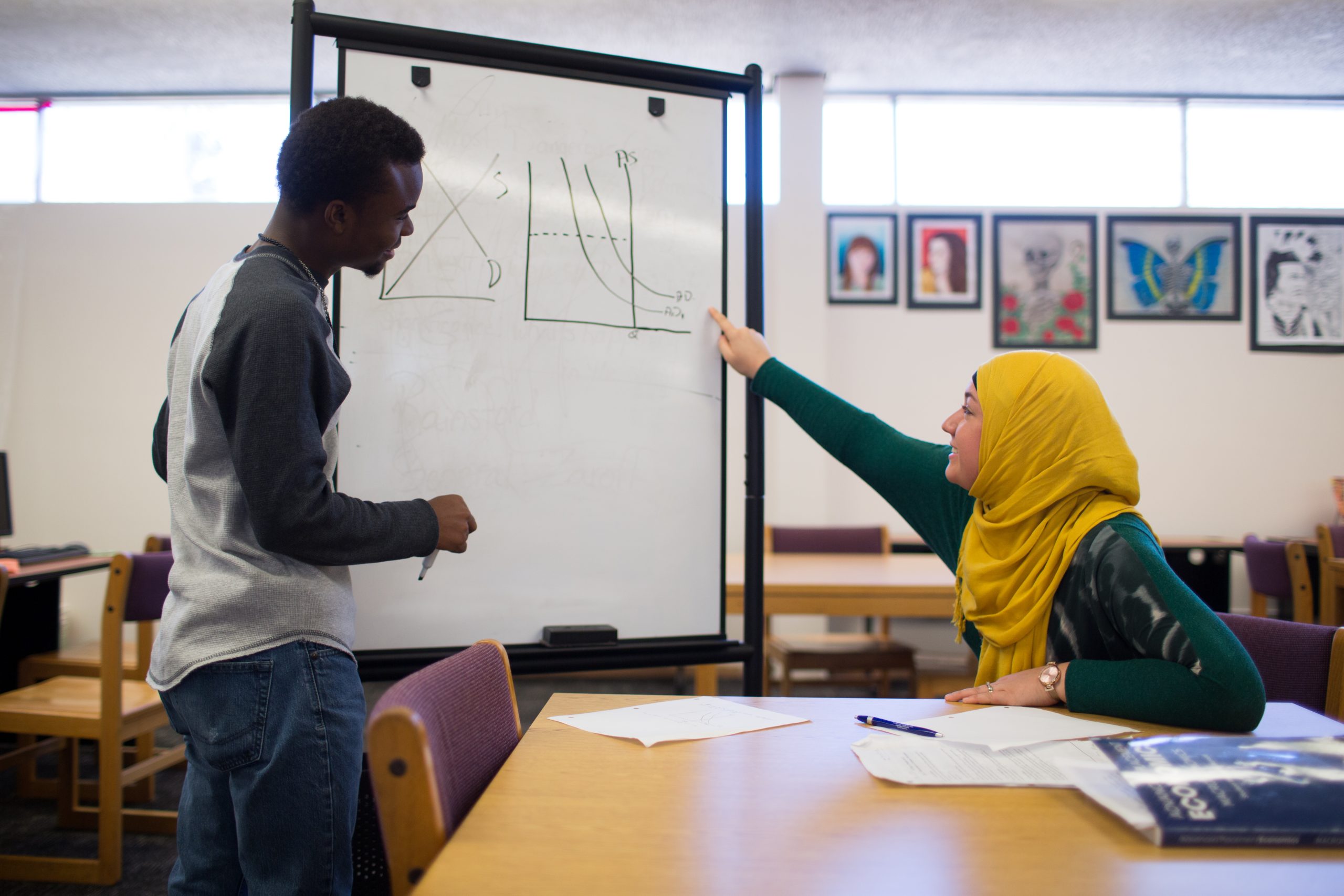 A student teaching mathematics with a whiteboard