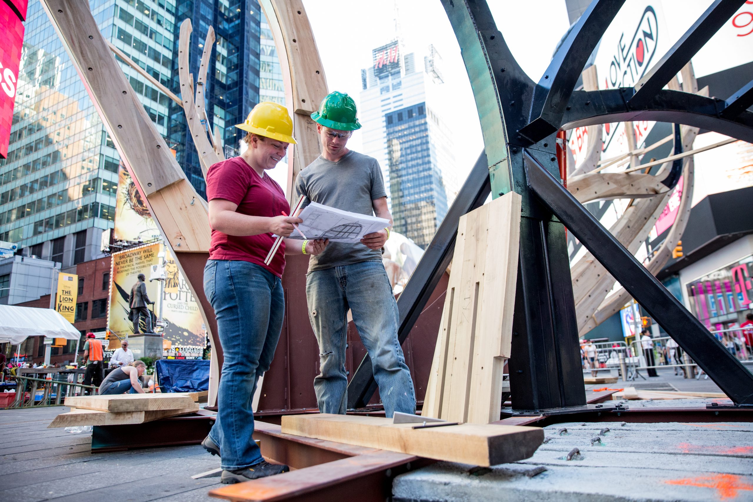 Two people constructing a STEAM studio art sculpture in times square