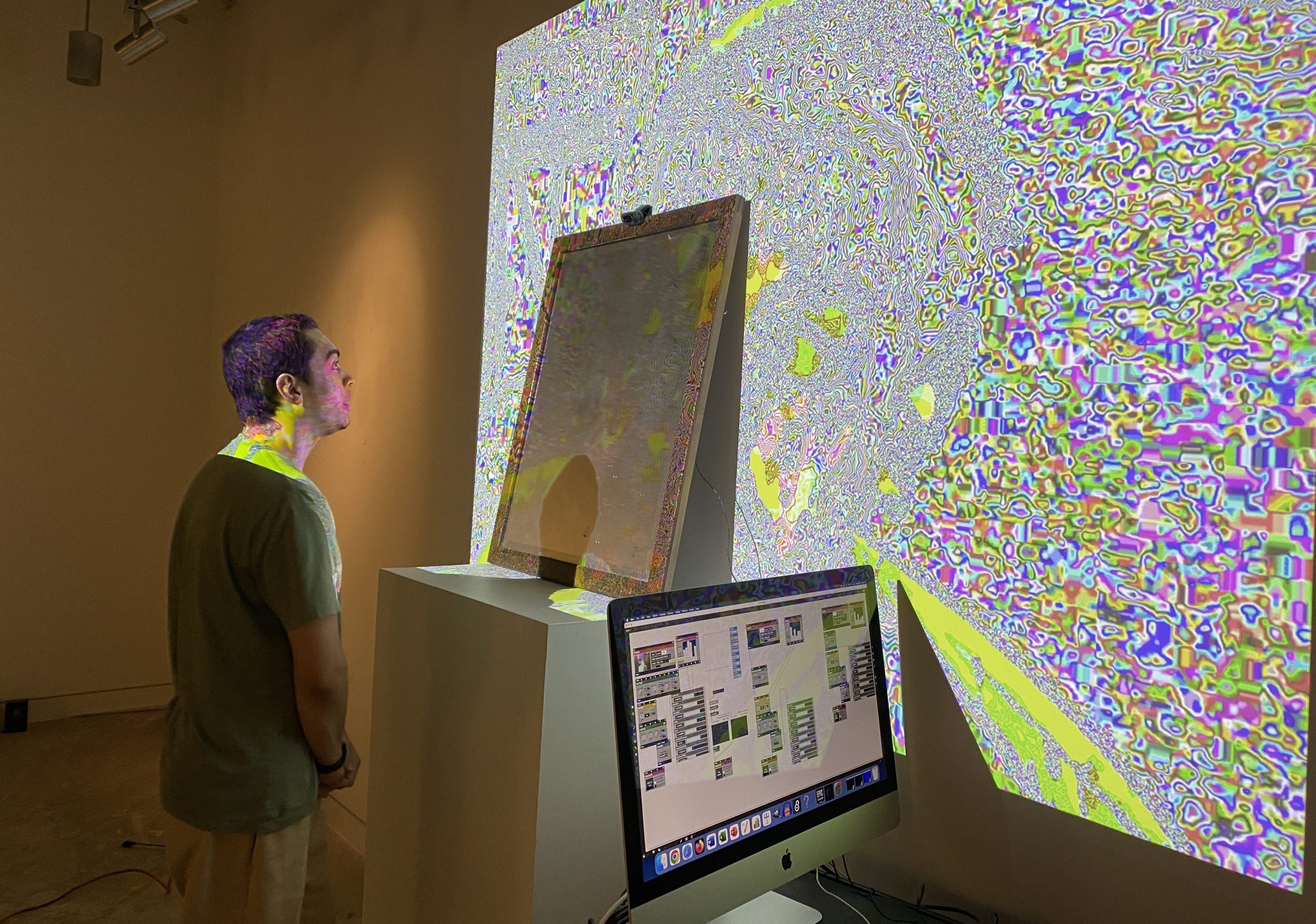 a new media student looks at a project being projected on a wall