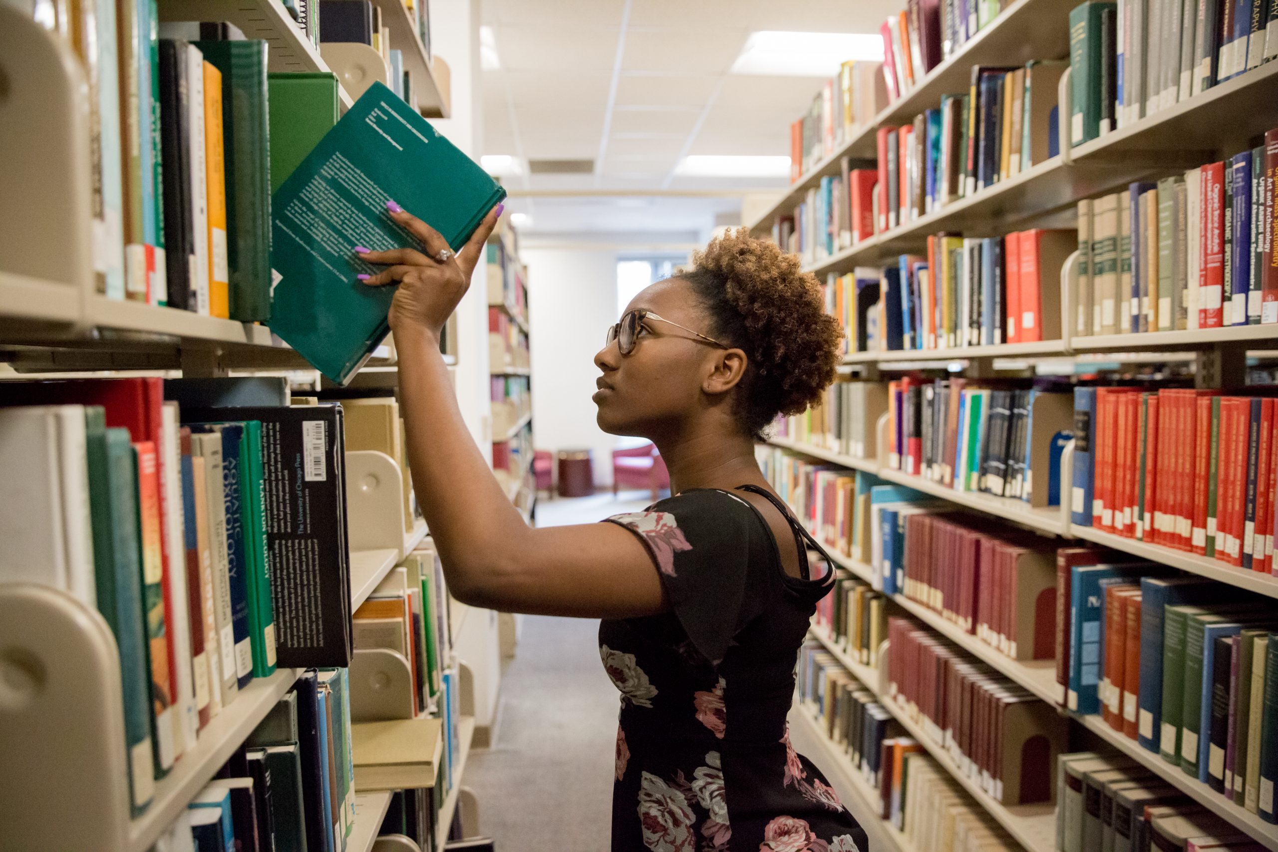 a student taking a book of a shelf in Ramsey library