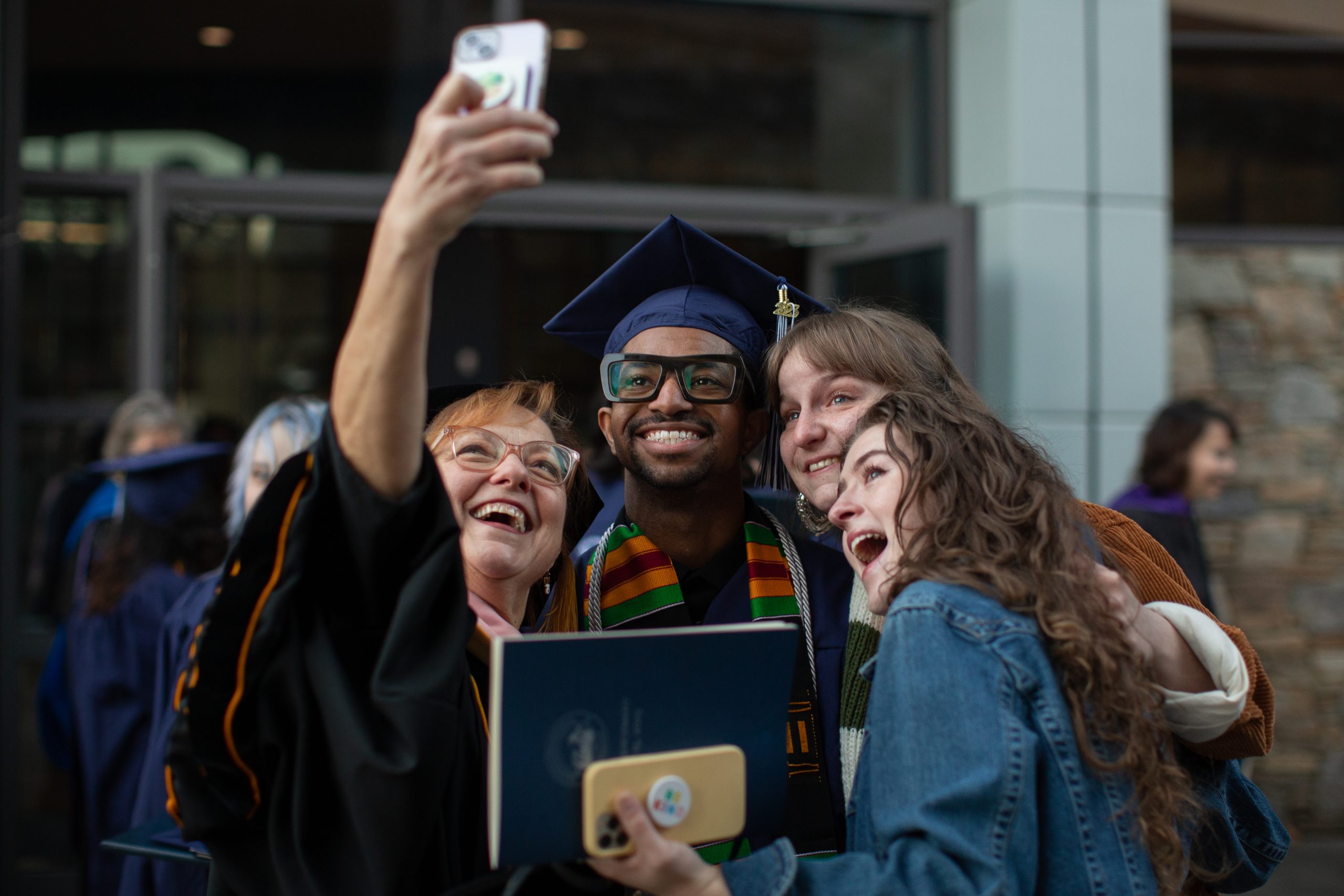 Some people taking a photo with a graduate outside Kimmel Arena after commencement