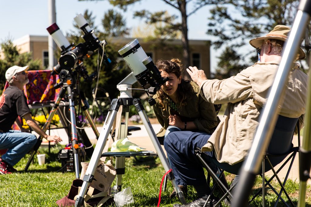 students on the quad using a telescope