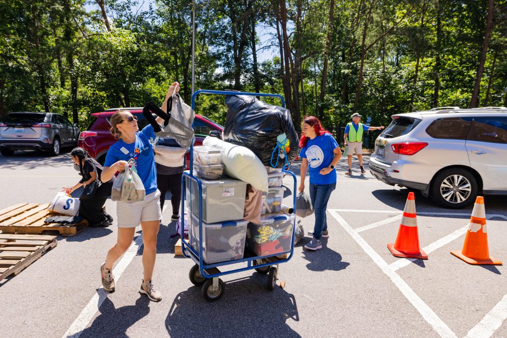 A student and their family loading up a luggage cart on move-in day, fall 2023