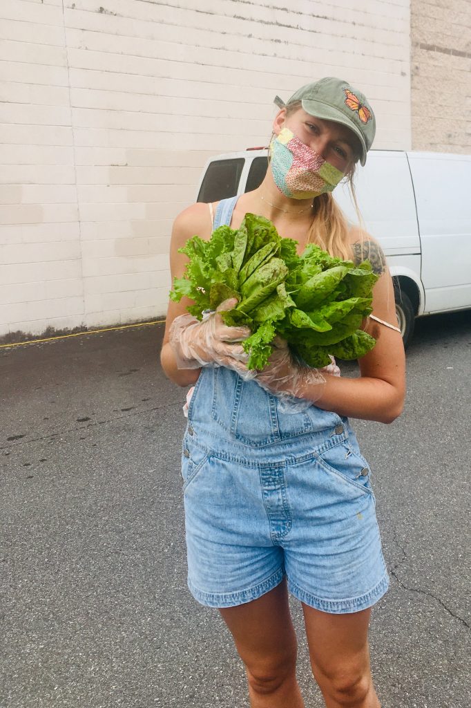 Spanish language student and Alumna Clair Edens holding cabbage