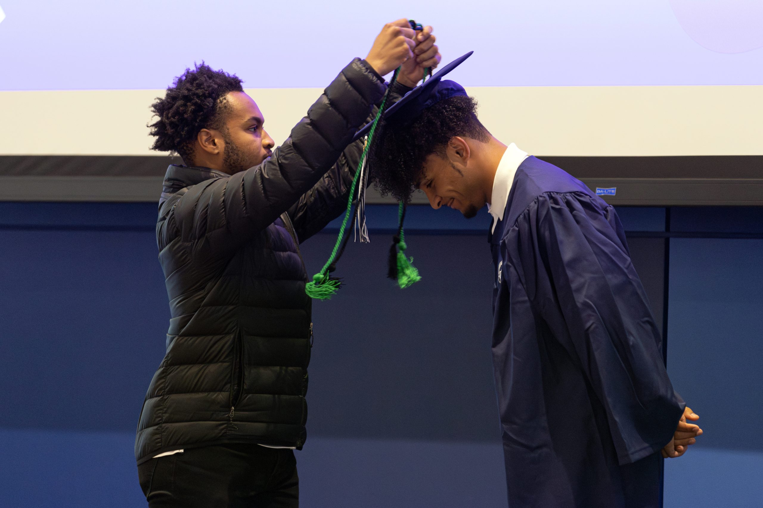 a first-generation graduate receiving a green chord