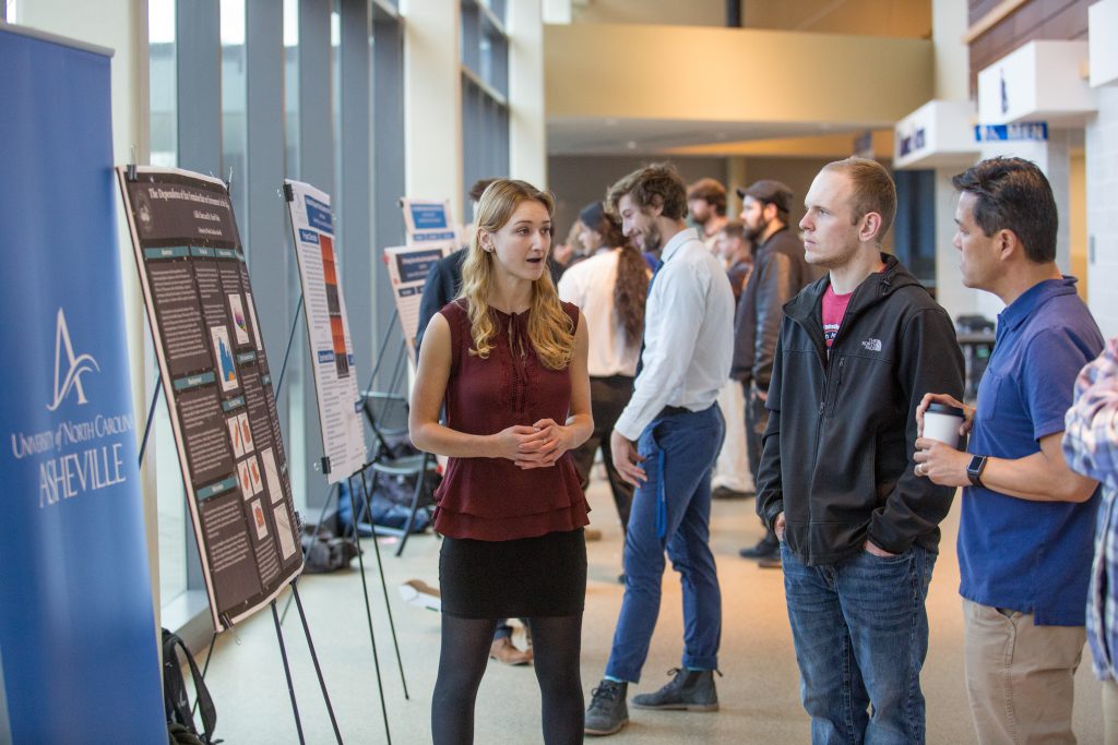 a student presenting a research project at an undergraduate research symposium