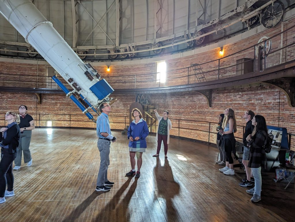 Students at Yerkes Observatory gathered around the large telescope