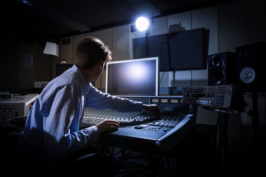 a student using audio equipment in a studio
