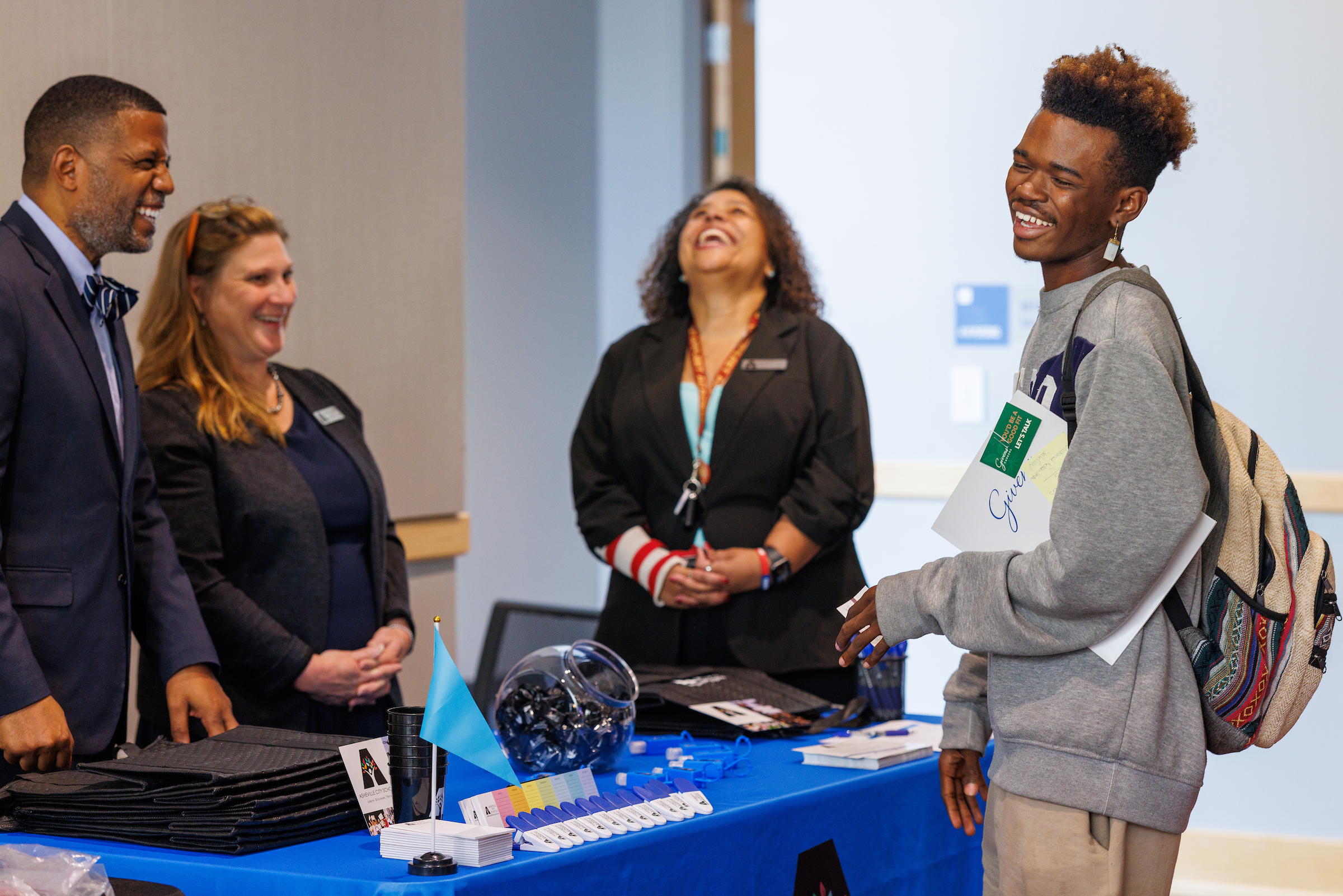 A student laughing with some people at a table, Career and Internship Fair Fall 2022