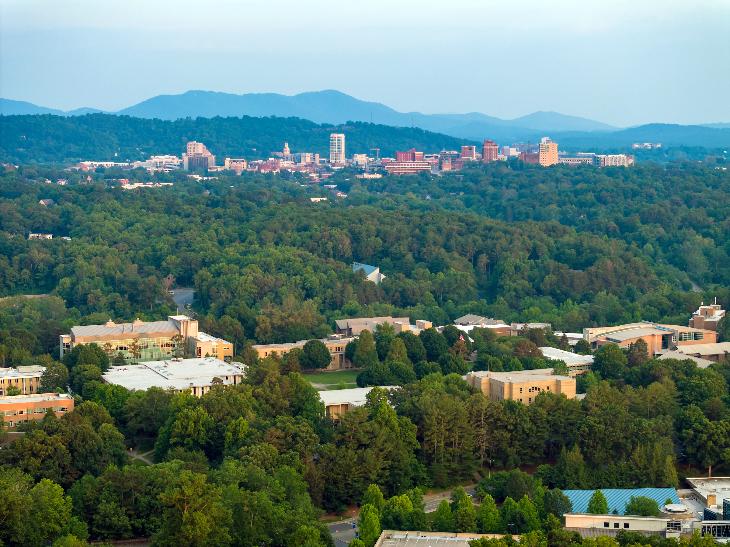 drone image of Unc asheville's campus and downtown asheville skyline