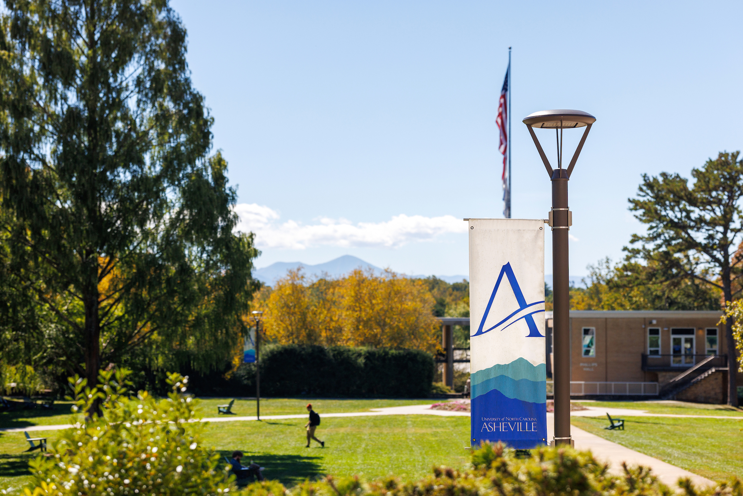 a shot of the quad with a unc asheville banner in the foreground and a flagpole in the background